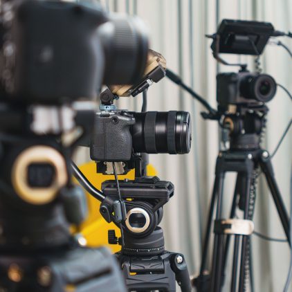 Videókamerák állványon a stúdióban (illusztráció)